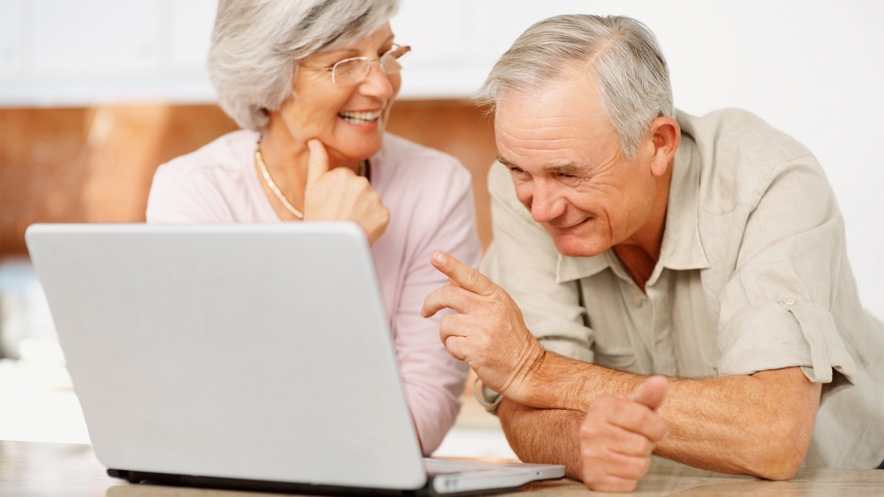 пожилые смотрят в компьютер и улыбаются